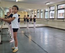 José, 11 anos posicionado em frente ao espelho. outras alunas estão na mesma posição atrás do bailarino