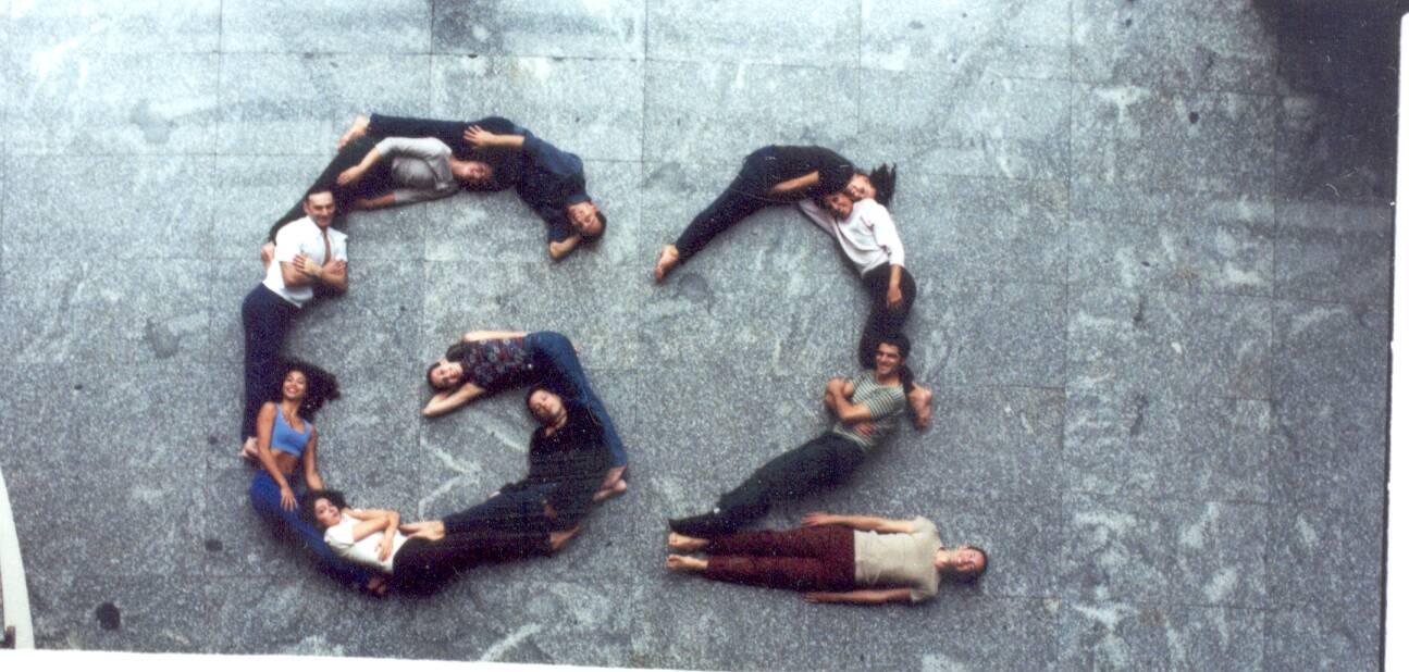 Bailarinos do G2 formam a sigla do grupo com o corpo, deitados no chão