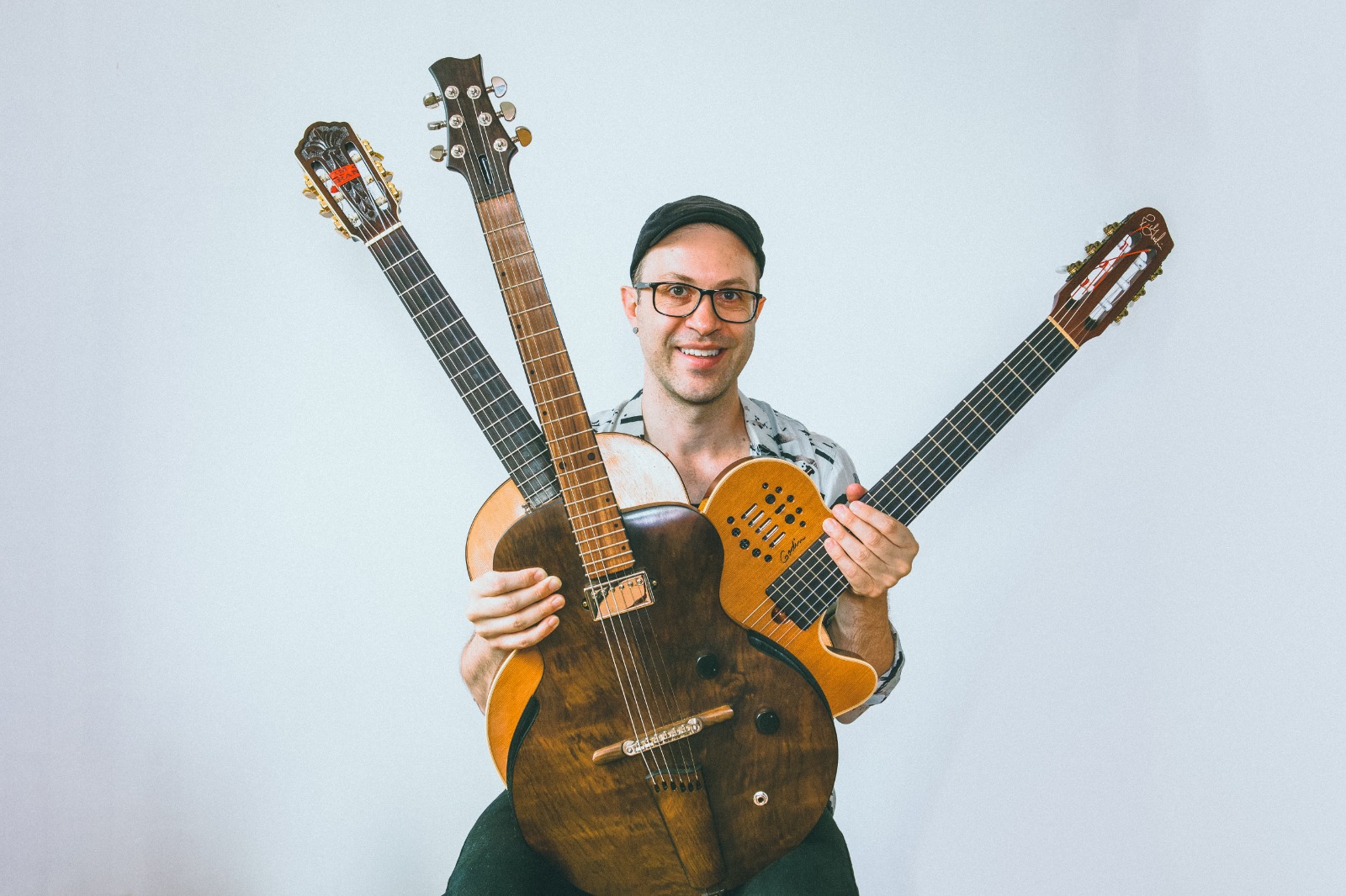 Músico Rodrigo Simões, com 3 instrumentos de corda