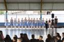 Grupo de dança se apresenta aos alunos no pátio da escola. As bailarinas vestem roupas na cor azul clara. 