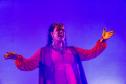 Elenco da ópera em cena com iluminação colorida