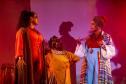 Elenco da ópera em cena com iluminação colorida