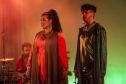 Elenco da ópera em cena com iluminação colorida