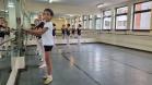 José, 11 anos posicionado em frente ao espelho. outras alunas estão na mesma posição atrás do bailarino