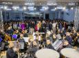 orquestra olha para camera ao fundo do palco. imagem também pega o publico que assistia
