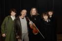 Romildo, Juliane e filhos. Juliane segura o violino na mão enquanto todos posam para foto