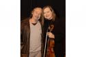 Juliane e Romildo atualmente. Juliane está com o violino em mãos