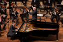 No palco do Guairão, a Orquestra Sinfônica do Paraná e o pianista Dmitry Shishkin