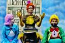 Personagens Ritinha, Doroteia e Nico em frente a uma prateleira da biblioteca