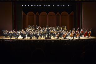 Foto dos músicos da OSP tocando no palco do Guairão durante um concerto