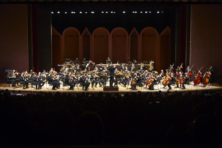 Foto dos músicos da OSP tocando no palco do Guairão durante um concerto