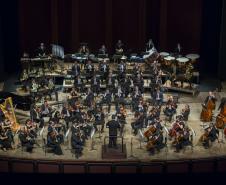 Foto de cima para baixo com toda a orquestra no palco do Teatro Guaíra