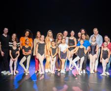 Mães e bailarinas e bailarinso da Escola se posicionam para registro. 