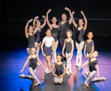 Mães e bailarinas e bailarinso da Escola se posicionam para registro. 