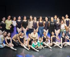 Mães e bailarinas e bailarinso da Escola se posicionam para registro. 