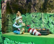 As fotos mostram as apresentações de várias modalidades do teatro de bonecos no Festival, com as crianças lotando as sessões e fazendo foto no boneco gigante e coloorido em frente ao Teatro Guaíra. 