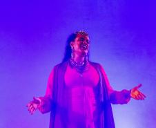 Elenco da ópera em cena com iluminação colorida