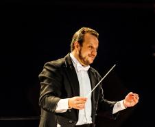 maestro Guilherme Mannis de terno em apresentação