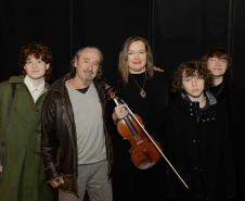 Romildo, Juliane e filhos. Juliane segura o violino na mão enquanto todos posam para foto