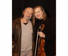 Juliane e Romildo atualmente. Juliane está com o violino em mãos