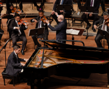 No palco do Guairão, a Orquestra Sinfônica do Paraná e o pianista Dmitry Shishkin