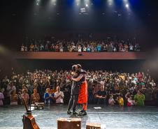 palhaços se abraçam no palco do Guairinha