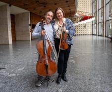 Entre tantos personagens e histórias, também nasceu uma história de amor. Foi tocando quase de frente um para o outro - ele no violoncelo, ela no violino - que Romildo Weingartner, músico desde a fundação da Orquestra em 1985, conheceu Juliane Martens.