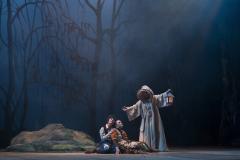 foto da ópera João e Maria contendo os personagens f=principais na floresta ao lado da bruxa. 