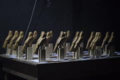 A premiação da edição anterior no placo do auditório Guairão e os troféus que os premiados vão receber, em formato de gralha azul, ave símbolo do Paraná. 