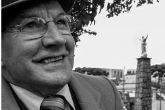 Emilio Pitta de terno e chapéu em uma praça