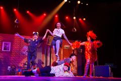 Atores em cena com iluminação vermelha