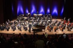 Orquestra e solista no palco do Guairão. 