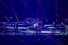 banda no palco com jogo de luzes em azul e vermelho