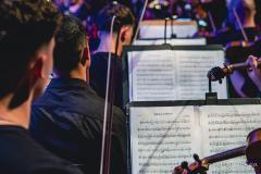 músicos enfileirados com partituras à frente