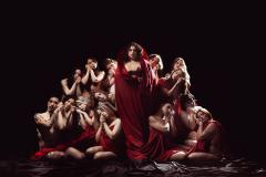 Grupo reunido com roupas vermelhas e fundo preto