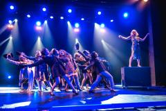 cena de Bombshell - iluminação azul e atores dançando em direção à personagem que representa Marilyn Monroe