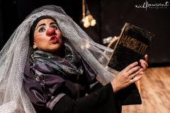 palhaça com tecido simulando um véu enquanto lê MACBETH