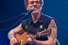 Nando Reis com seu violão em um palco