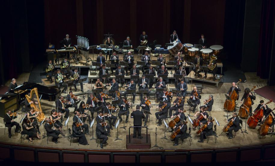 Foto de cima para baixo com toda a orquestra no palco do Teatro Guaíra