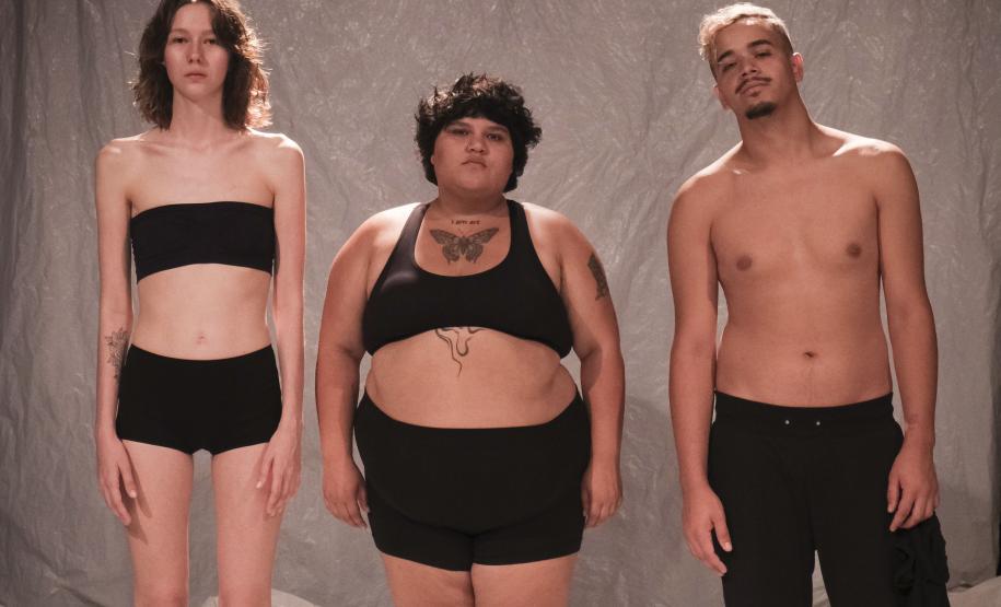 As fotos mostram parte das cenas criandas, com três atores e material plástico sendo enrolado nos corpos deles.