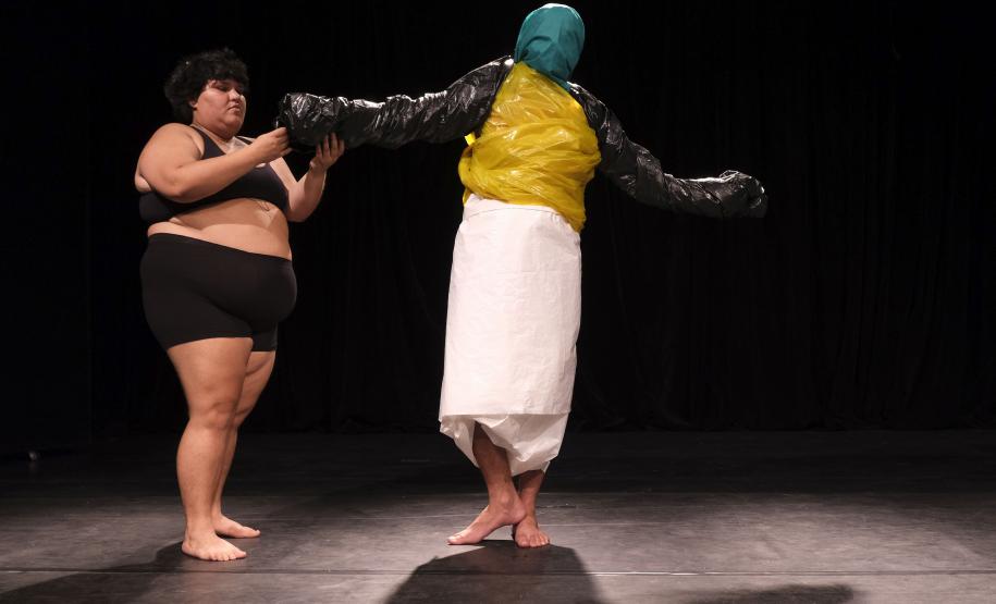 As fotos mostram parte das cenas criandas, com três atores e material plástico sendo enrolado nos corpos deles.