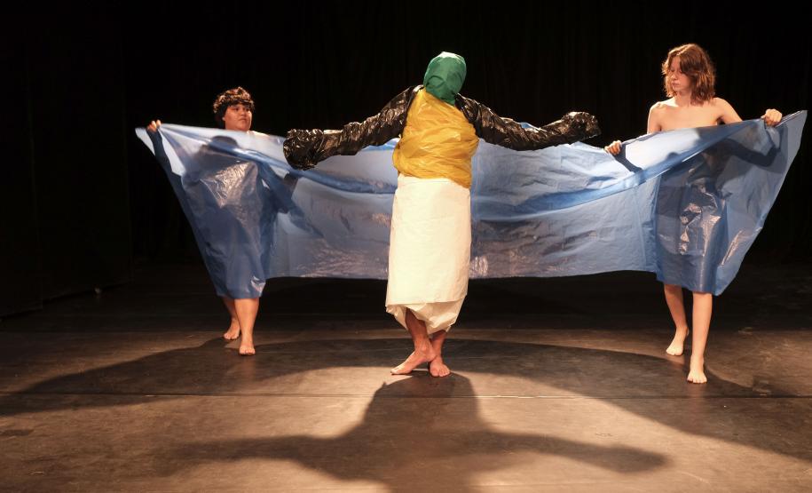 As fotos mostram parte das cenas criandas, com três atores e material plástico sendo enrolado nos corpos deles.