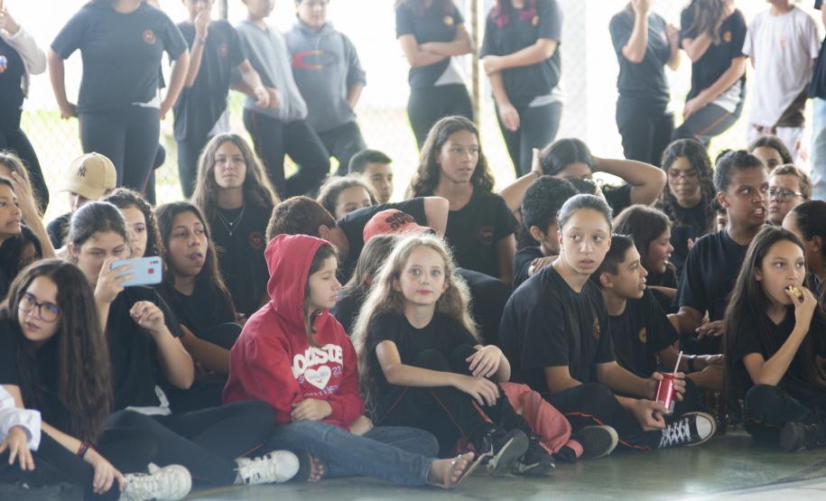 O grupo de dança da EDTG dança no pátio do Colégio Estadual Ipê, diante dos olhoares atentos dos alunos.