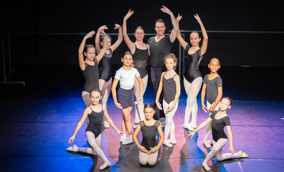 Mães e bailarinas e bailarinso da Escola se posicionam para registro.