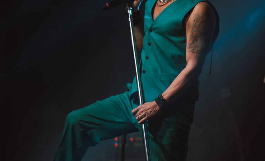 Paulo Ricardo em shows. O palco possui iluminação colorida. Em uma das fotos o artista canta, e nas outras toca baixo.