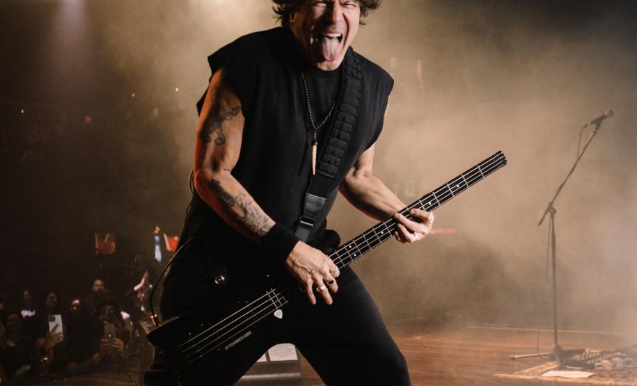 Paulo Ricardo em shows. O palco possui iluminação colorida. Em uma das fotos o artista canta, e nas outras toca baixo.