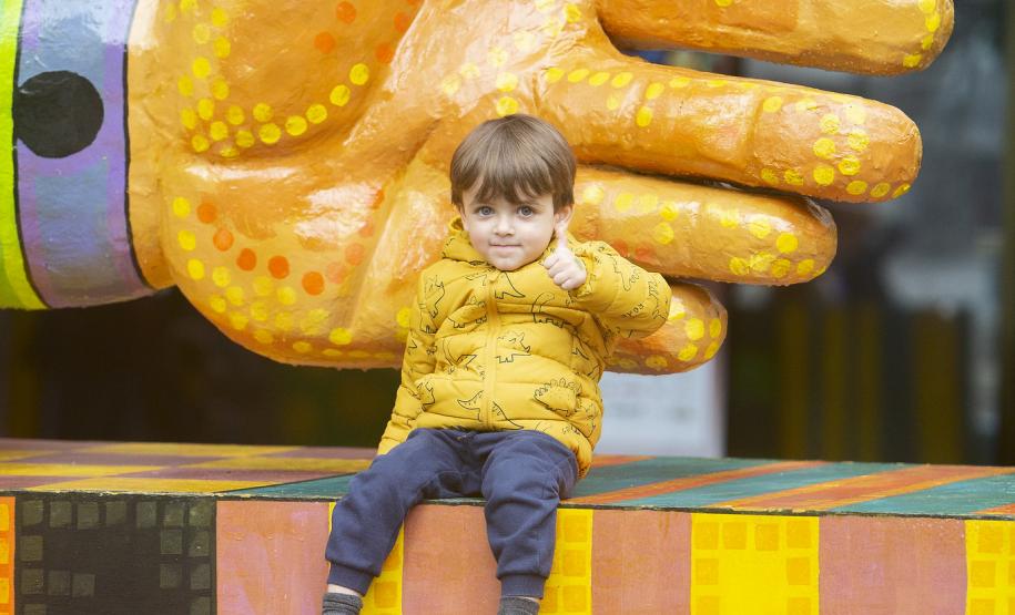As fotos mostram as apresentações de várias modalidades do teatro de bonecos no Festival, com as crianças lotando as sessões e fazendo foto no boneco gigante e coloorido em frente ao Teatro Guaíra.