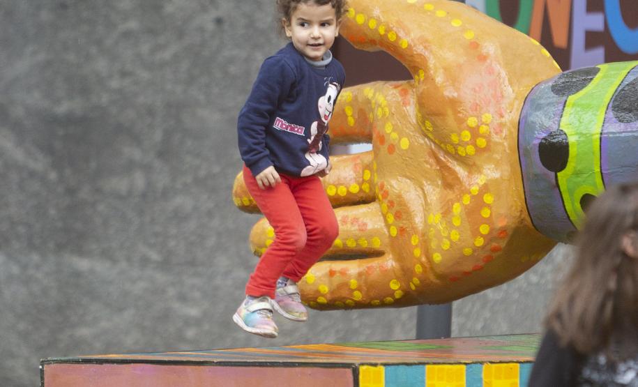 As fotos mostram as apresentações de várias modalidades do teatro de bonecos no Festival, com as crianças lotando as sessões e fazendo foto no boneco gigante e coloorido em frente ao Teatro Guaíra.