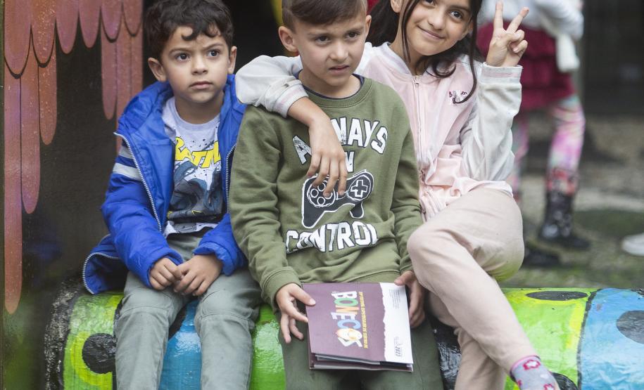 As fotos mostram as apresentações de várias modalidades do teatro de bonecos no Festival, com as crianças lotando as sessões e fazendo foto no boneco gigante e coloorido em frente ao Teatro Guaíra.