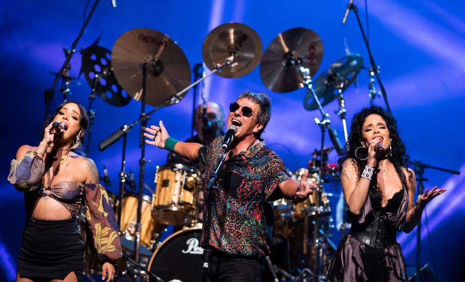 banda em cima do palco com instrumentos ao fundo